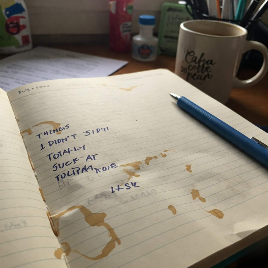 Imperfect Wins: Coffee-Stained Notebook on a Cluttered Desk